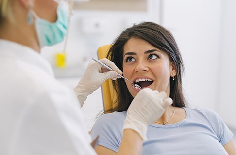 A dentist assessing a woman’s infected gums