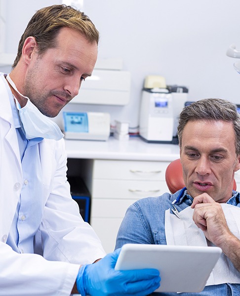 Dentist and patient looking at tablet together