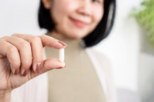 Close up of doctor holding a pill between her fingers